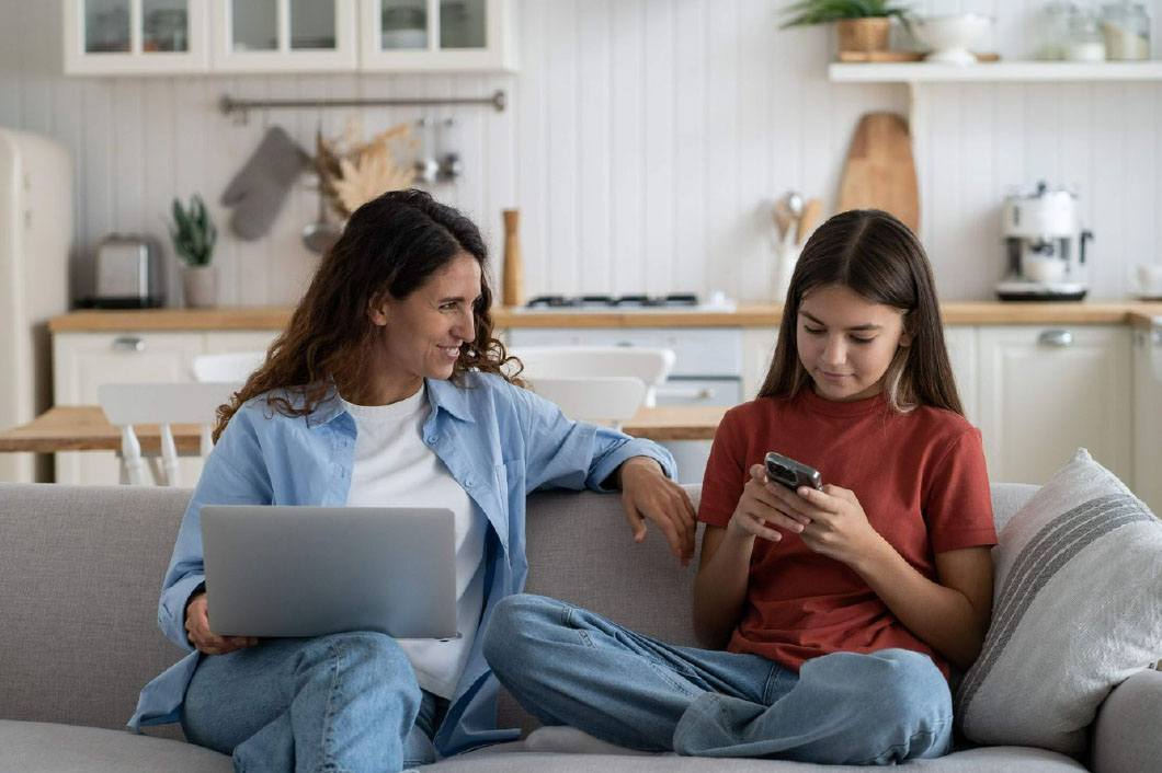 Mom on laptop talking to daughter on phone