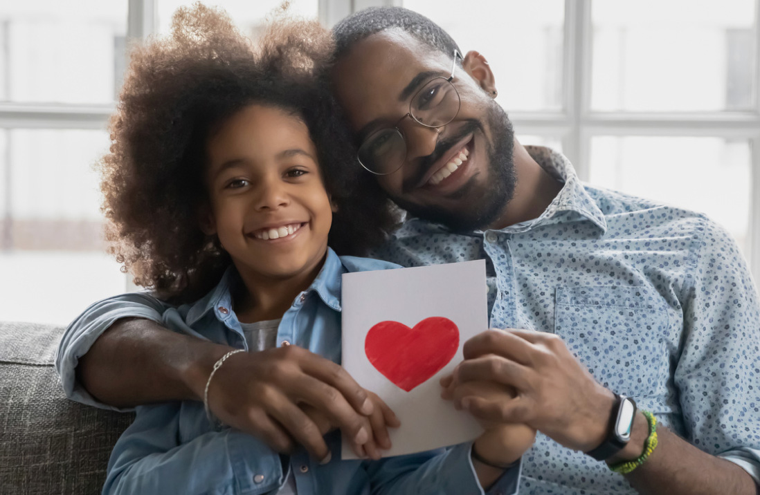 Father and daughter holding paper with heart